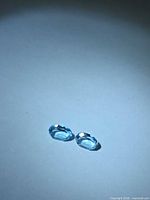 pair of oval blue topaz gemstones on plain background