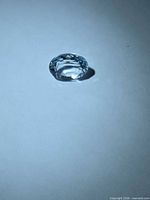 Side view of faceted oval aquamarine on white background