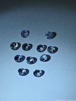 11 round tanzanites under cool lighting