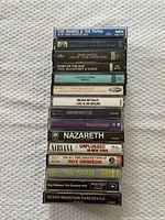 Stack of 15 cassette spine labels showing artist and album names