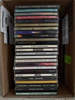 Vertical stack of approximately twenty-two CD spines showing titles and artists