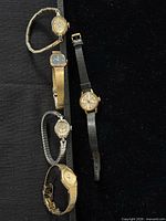 All five watches laid out on black background