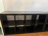 Front view of black cube shelving unit showing all eight open cubbies