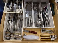 Open drawer showing all flatware and utensils laid in organizers