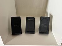 Front view of three identical style black wireless charging stands