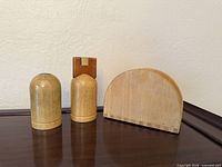 Front view of wood salt mill, pepper shaker with crown top, and half-circle magazine holder