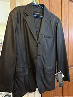 Full front view of Charles Klein leather jacket on hanger