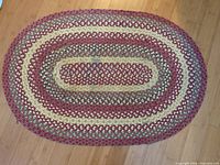 Full view of oval braided rug showing pattern and colors