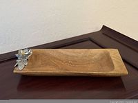 Top view of acacia tray showing pewter flower detail and wood grain