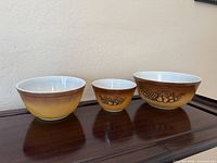 Front view of three nested Pyrex Old Orchard bowls showing sizes and exterior pattern