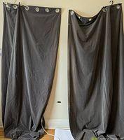 Two gray floor-length curtain panels hanging, showing overall appearance and length