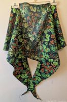 Scarf draped on hanger showing overall fabric and pattern