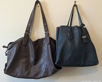 Front view of both leather bags hanging side by side