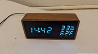Front view showing wood case and blue LED time, humidity, temperature