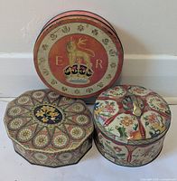 Group shot of three tins showing shapes, designs and relative sizes