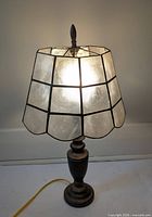 Lamp lit showing capiz shell shade panels and metal base