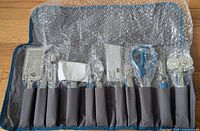 Full set in open roll pouch showing ten bubble-wrapped utensils