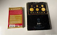 Back cover of coin guide and worn back of auction catalogue