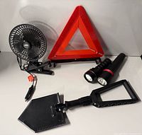 Overview of all items: fan, warning triangle, two flashlights, folding shovel