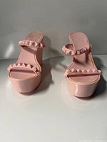 Front view of both sandals showing studded straps and platform height