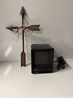 Front view of Tatung Heat Devil heater and metal arrow décor