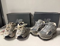 Two pairs of New Balance sneakers with boxes