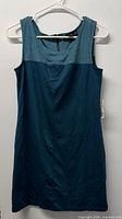 Front view of teal sleeveless dress on hanger