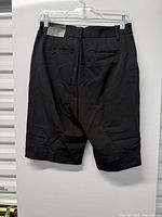 Back view of black knee-length shorts on hanger