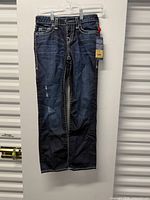 Full view of jeans hanging showing overall condition and style