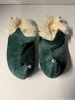 Top view of both green curl-toe slippers showing overall style and bells