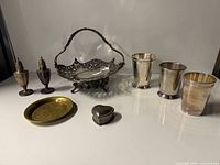 Group shot of all metal tableware pieces arranged on surface