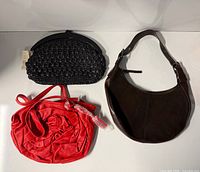 Overview of three handbags on white surface