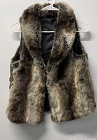 Front view of faux fur vest hanging on hanger