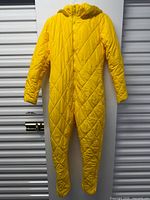 Front view of yellow quilted one-piece women’s snowsuit hanging