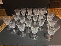 Group view of 25 clear cut crystal wine glasses arranged in rows