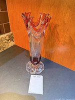 Full view of red and clear crystal vase standing upright