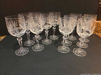 Twelve crystal wine glasses in two rows showing full lot