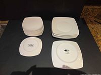 Stacks of white square plates showing two sizes