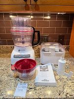 Full lot showing food processor assembled, juicer, blade caddy, manual, additional blade