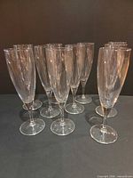 Front angled view of all 10 clear glass flutes standing
