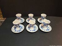 Group shot of six egg cups each on its saucer