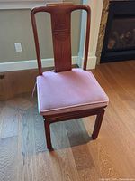 Front view of solid wood dining chair with pink cushion