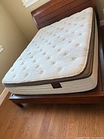 Full view of queen mattress on wooden bed frame