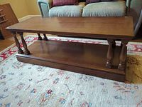 coffee table front view showing lower shelf and turned legs