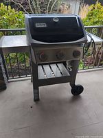 Front view of Weber Spirit II grill with lid closed and side shelves.