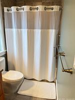 Shower curtain set installed with bath mat visible
