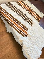 Wool throw draped with sheepskin rug on floor showing overall look