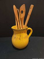 Pitcher holding four bamboo utensils front view