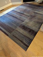 Full view of rectangular striped rug on hardwood floor