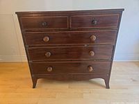 Front view of dresser showing 5 drawers, keyholes, turned knobs and overall condition